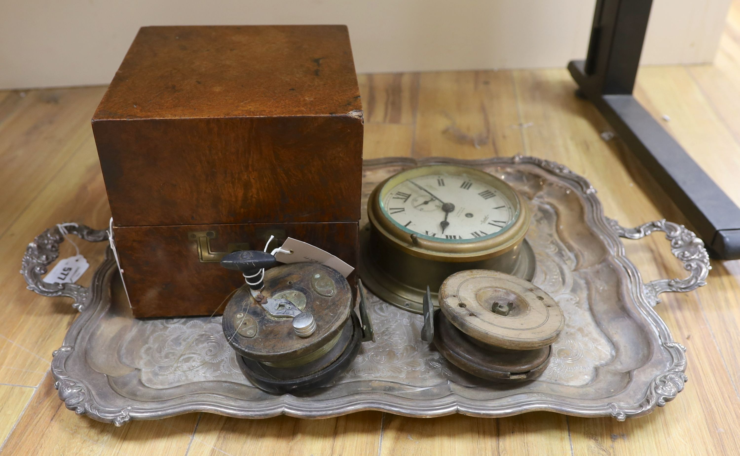 A 19th century amboyna box, 22cm wide, a Sestrel ship's wall clock, no key - 20cm diameter, a large plated two-handled tray - 71cm long, Vintage Ogden Smith fishing reel together with another (5)